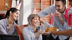 Excited diverse workers congratulate colleague with birthday in office