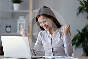 Excited ecstatic teen girl winner celebrating victory looking at laptop
