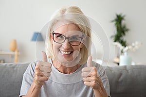 Excited elderly woman show thumbs up recommending something