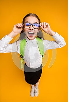 Excited Elementary School Girl In Eyewear Posing On Yellow Background