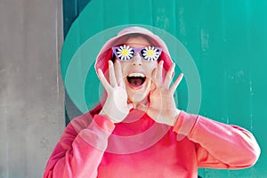 Excited emotional loudly shouting, woman in sunglasses with flowers stickers. Playful woman with pink hair,bucket