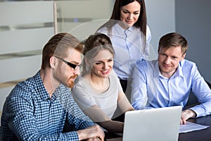 Excited employees looking at laptop observing growing statistics