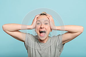 Excited enthusiastic woman scream hold head hands