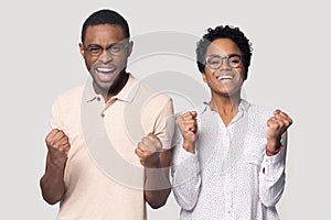 Excited ethnic couple wearing glasses feel overjoyed with news