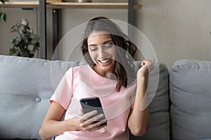 Excited ethnic woman get pleasant message on cell