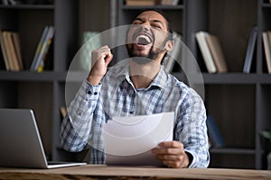 Excited euphoric Black student guy receiving admission letter from school