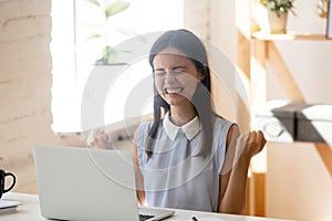 Excited euphoric millennial woman enjoy moment of victory