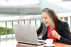Excited executive reading notification in a laptop