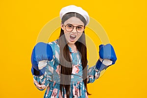 Excited face. Teenage boxer girl in boxing gloves on yellow isolated background. Amazed expression, cheerful and glad.