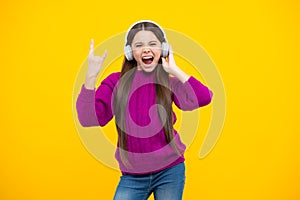 Excited face. Young teen child listening music with headphones. Girl listening songs via wireless headphones. Wireless