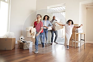 Excited Family Carrying Boxes Into New Home On Moving Day