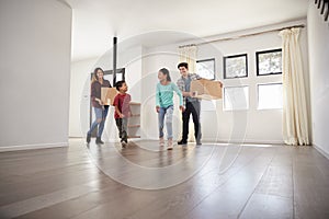 Excited Family Carrying Boxes Into New Home On Moving Day