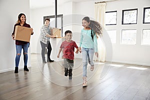 Excited Family Carrying Boxes Into New Home On Moving Day