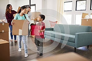 Excited Family Carrying Boxes Into New Home On Moving Day