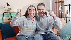 Excited family couple surprised, shocked by sudden victory, good win news, celebrating, wow reaction