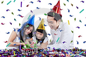 Excited family cutting birthday cake