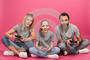 excited family playing video game with joysticks, isolated