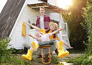 Excited family playing with wheelbarrow