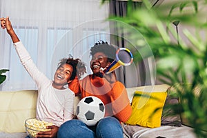 Fmily watching football match at home. Mother and daughter having fun at home