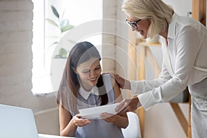 Excited female employee get monetary gratitude from boss photo