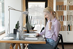 Excited female employee triumph with good email on laptop