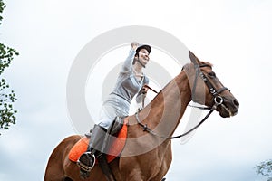 Excited female equestrian while riding horse holding reins