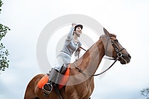Excited female equestrian while riding horse holding reins photo