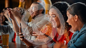 Excited Female Holding a Smartphone, Sitting at a Bar Stand. Nervous About the Sports Bet She Put on