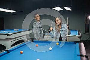 excited female pool player clenched her arm while playing the billiard