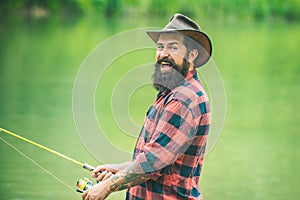 Excited fisher man fishing with spinning reel. Trout on a hook. Difference between fly fishing and regular fishing.