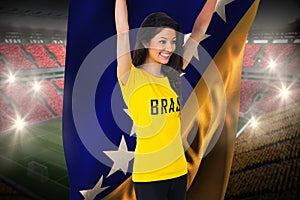 Excited football fan in brasil tshirt holding bosnia flag