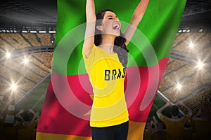 Excited football fan in brasil tshirt holding cameroon flag