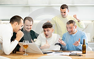 Excited friends cheering winning score in online game