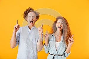 Excited friends loving couple pointing.