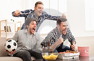 Excited friends watching football match and shouting