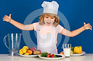 Excited funny chef cook. Fruits and vegetables for kids. Portrait of chef child in cook hat. Cooking at home, kid boy