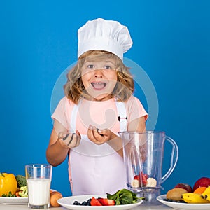 Excited funny chef cook. Portrait of chef child in cook hat. Cooking at home, kid boy preparing food from vegetable and