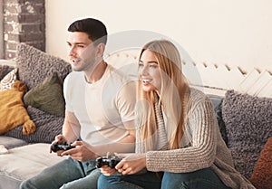 Excited funny couple playing video games at home