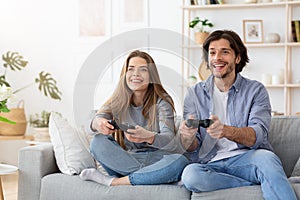 Excited funny couple playing video games at home