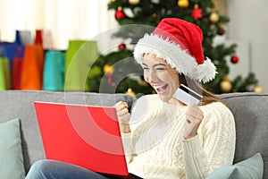 Excited girl holding a card shopping online on christmas