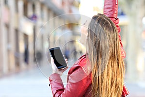 Excited girl holding phone and showing screen