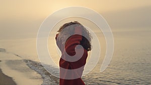 Excited girl jumping on beach. Smiling woman turning around on sea coast