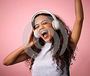 Excited girl, listening and music with headphones for hip hop, rock or beats on a pink studio background. Happy female