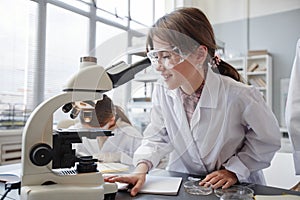 Excited Girl Looking in Microscope in Science Lab