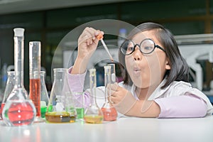 Excited girl making experiment with test tube