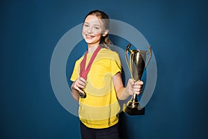 Excited girl with medals and trophy cup