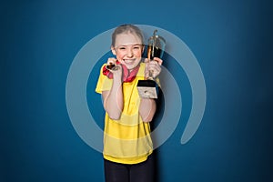 Excited girl with medals and trophy cup