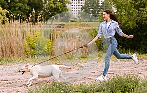 Excited girl and retriever running in countryside