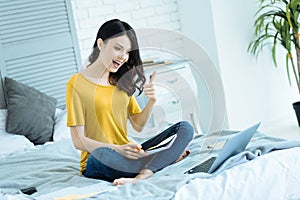 Excited girl showing thumb up while studying