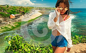 Excited girl standing on top mountain cliff and enjoy amazing view nature landscape tropical island Bali